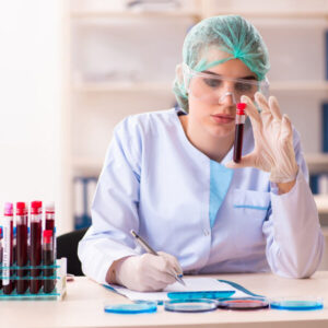 Lab Worker reviewing blood test container